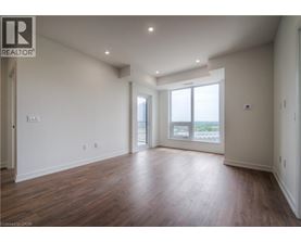 A spacious room with wooden floors and a large window.