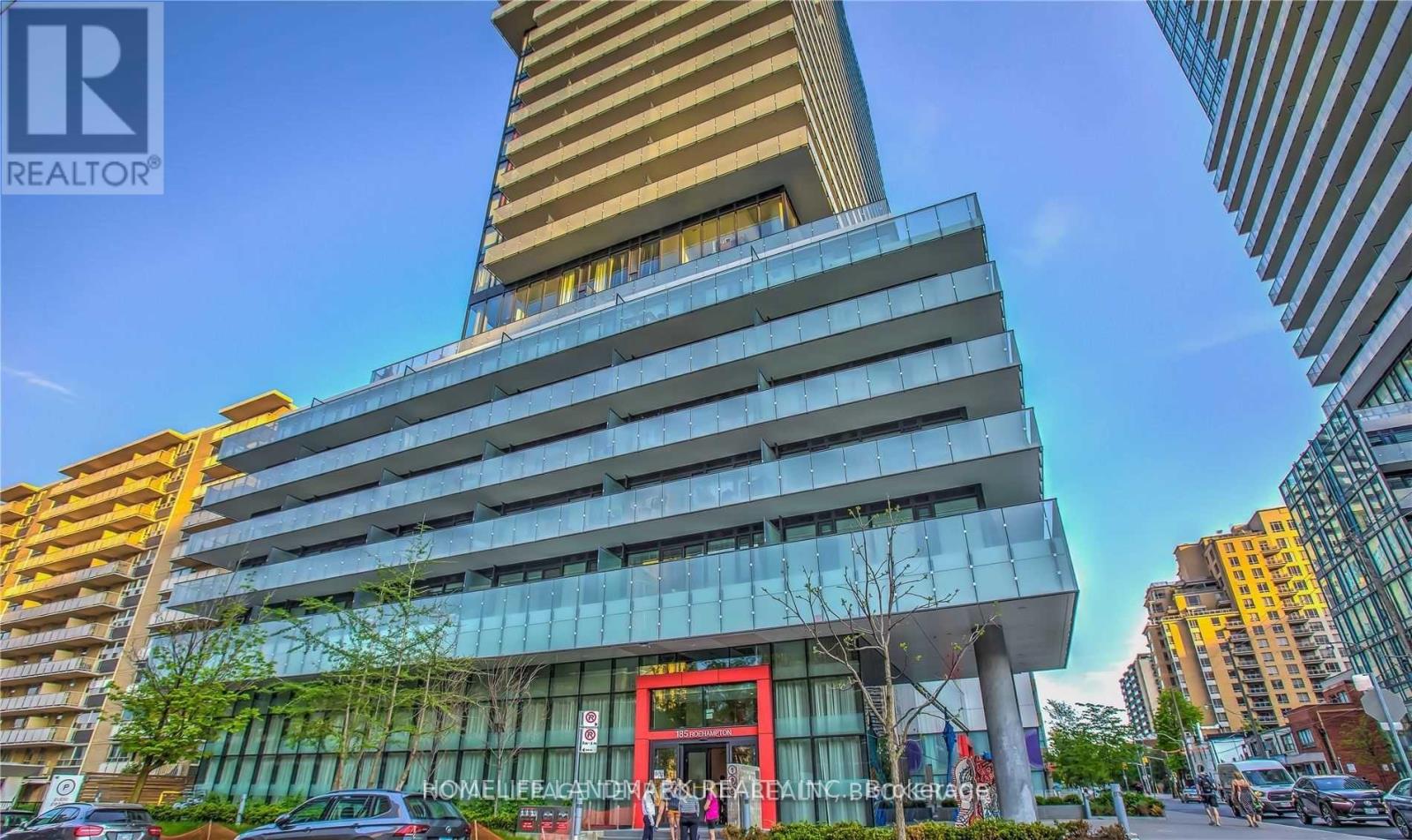 A modern building with a glass facade and a red entrance sign.