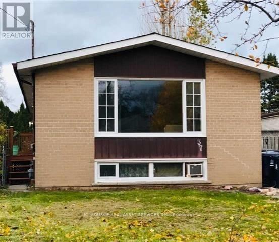 A small house with a brown and beige exterior and a large window.