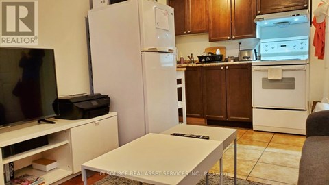 A kitchen with a refrigerator, oven, and microwave.