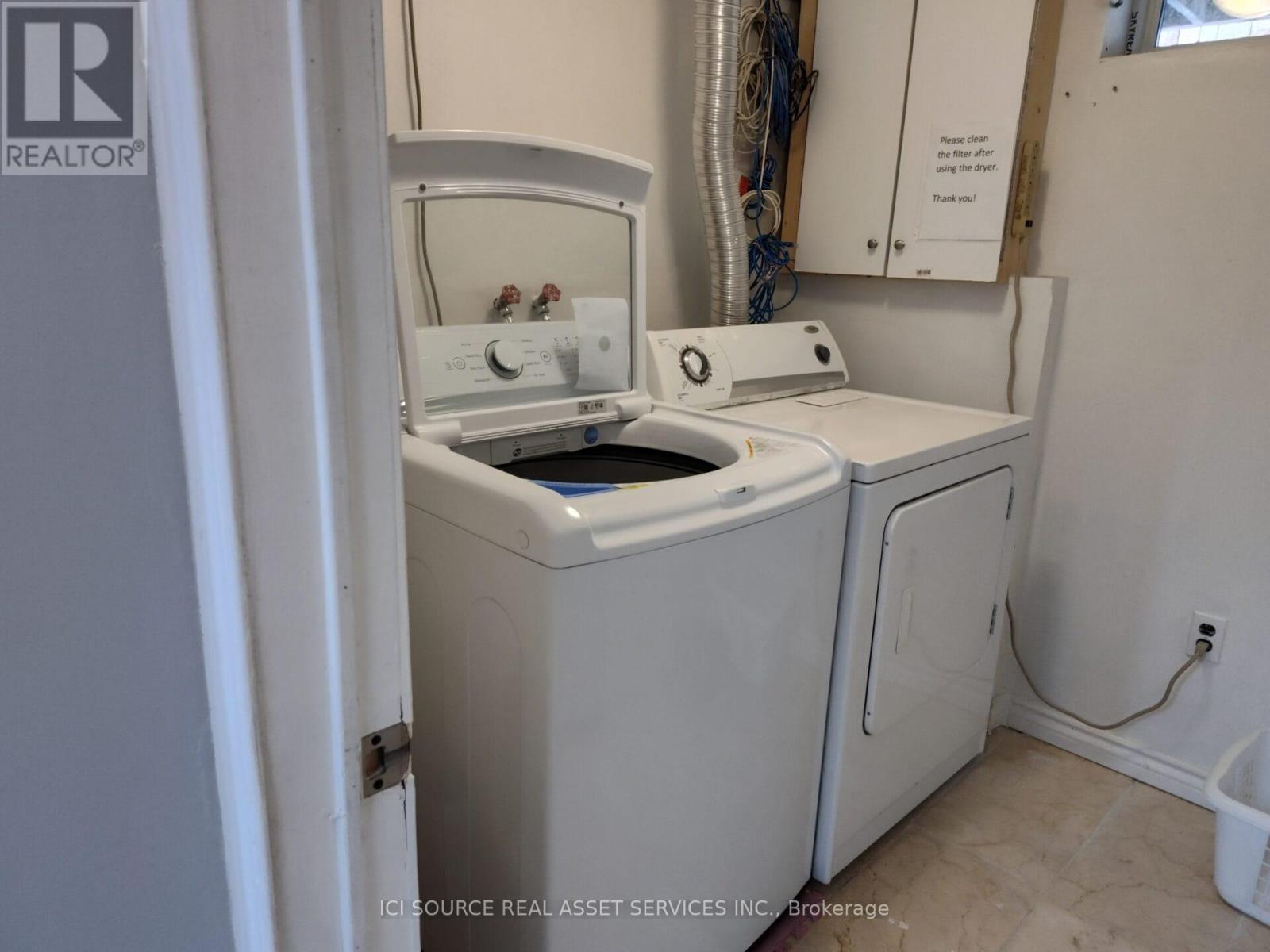 A white washing machine and dryer in a small laundry room.