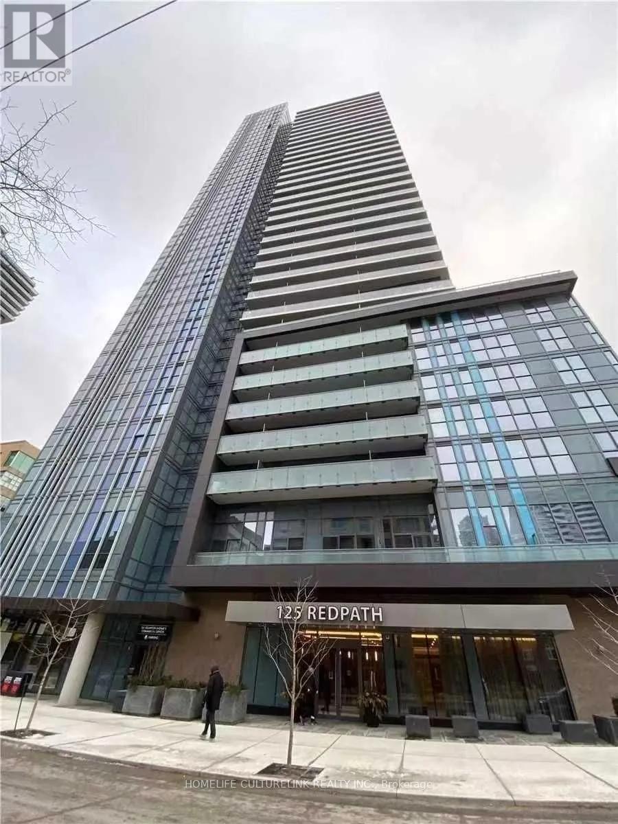 A tall building with a glass facade and a sign that reads "125 REDPATH" in front of it.
