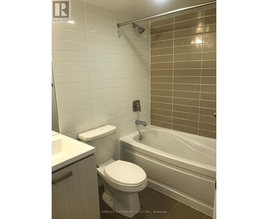 A white toilet sits next to a bathtub in a bathroom.