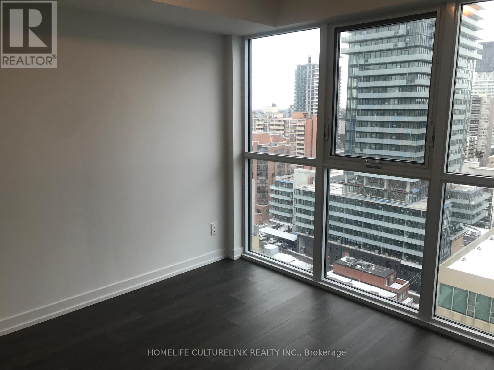 A room with a large window overlooking a cityscape.