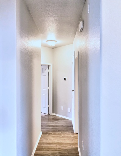 A hallway with a door on the right and a light on the ceiling.