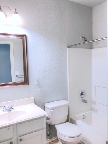 A white toilet sits next to a white sink in a bathroom.