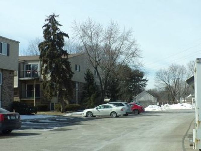 A car is parked in a driveway in front of a house.