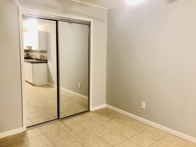 A room with a sliding glass door leading to a bathroom.