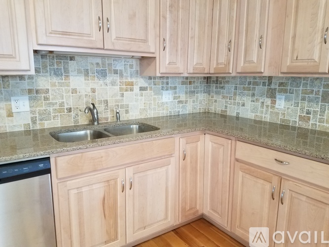 A kitchen with wooden cabinets and a tiled backsplash.