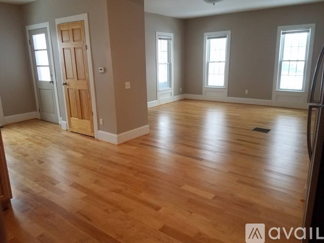 A room with wooden floors and a door in the center.