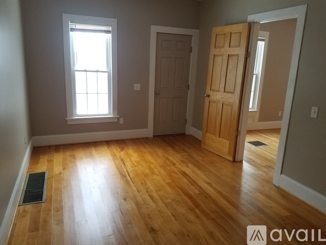 A room with wooden floors and a window letting in natural light.