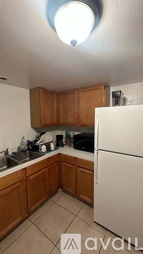 A kitchen with wooden cabinets and a white refrigerator.