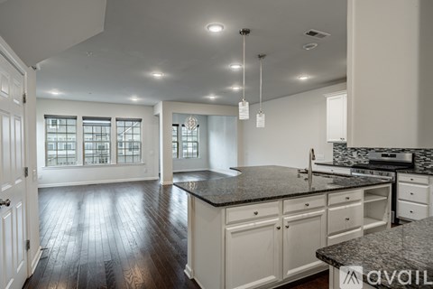 A kitchen with white cabinets and a black countertop.
