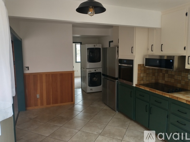 A kitchen with a refrigerator, oven, and microwave.