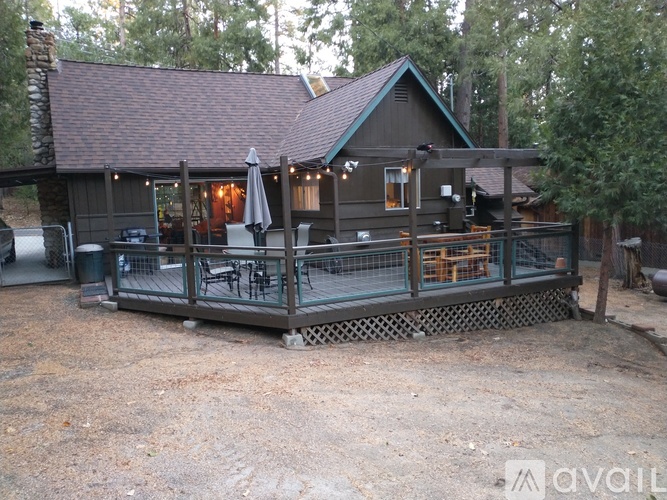 A wooden house with a porch and a table set up for dining.