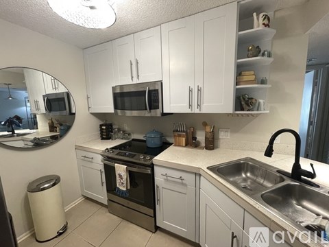 A kitchen with white cabinets and a black stove top.