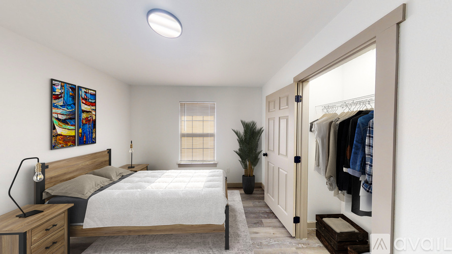 A bedroom with a bed, desk, and a painting on the wall.