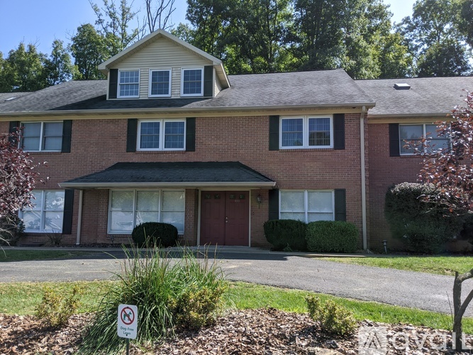 A house with a red door and a sign in front of it.