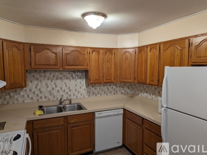A kitchen with wooden cabinets and a white refrigerator.