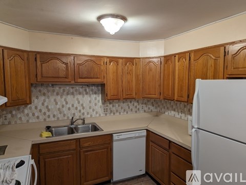 A kitchen with wooden cabinets and a white refrigerator.