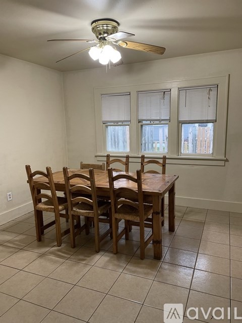 A dining room with a table and chairs.