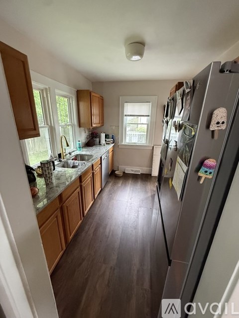 A kitchen with wooden cabinets and a tiled floor.
