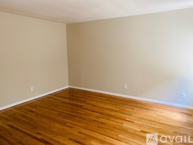 A room with wooden flooring and white walls.
