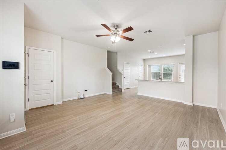 A spacious room with a ceiling fan and lighting fixture.