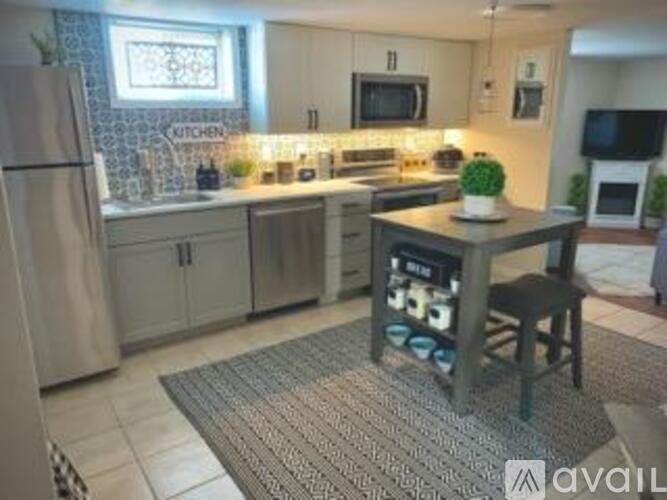 A kitchen with a refrigerator, a table, and a chair.