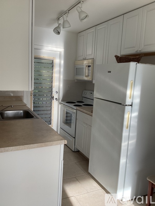 A kitchen with white appliances and cabinets.