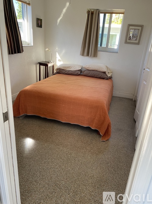 A bedroom with a bed and a window with curtains.