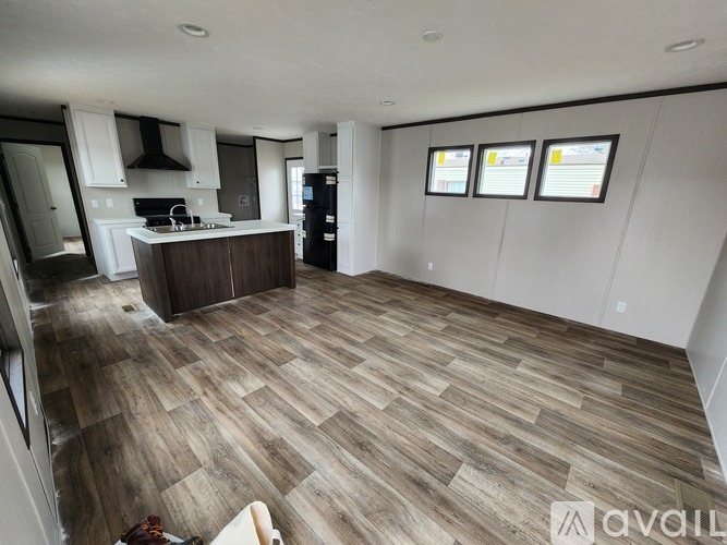 A kitchen with a wooden floor and white walls.