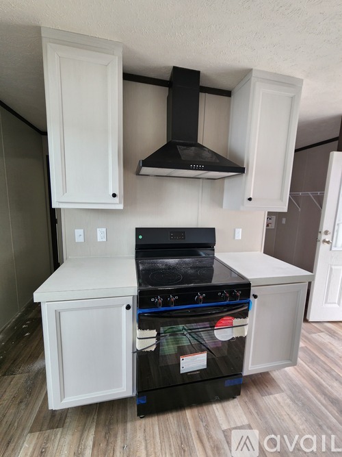 A black stove top oven with a white cabinet above it.