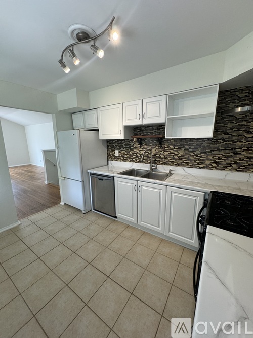 A kitchen with a black counter top and white cabinets.