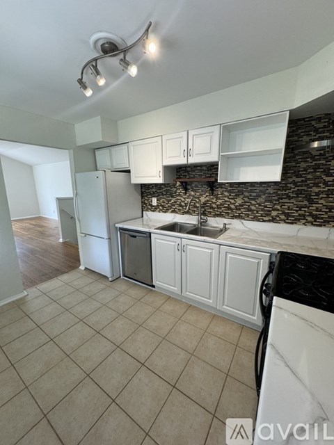 A kitchen with a black counter top and white cabinets.