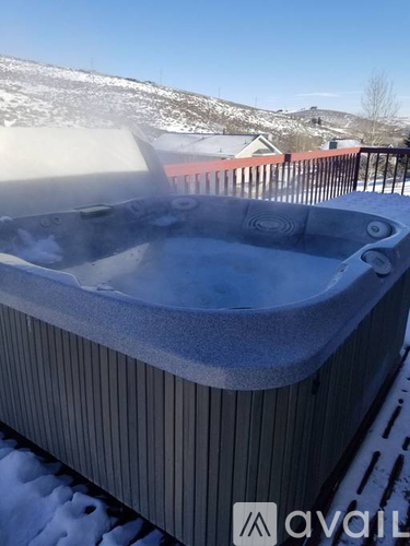 A hot tub on a balcony with snow on the ground.
