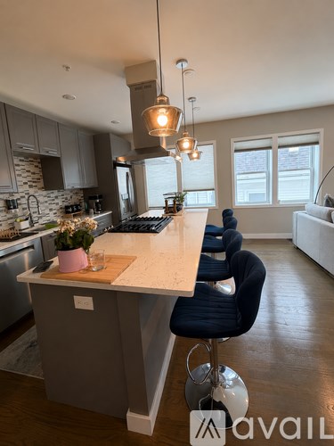 A modern kitchen with a stove top in the foreground.