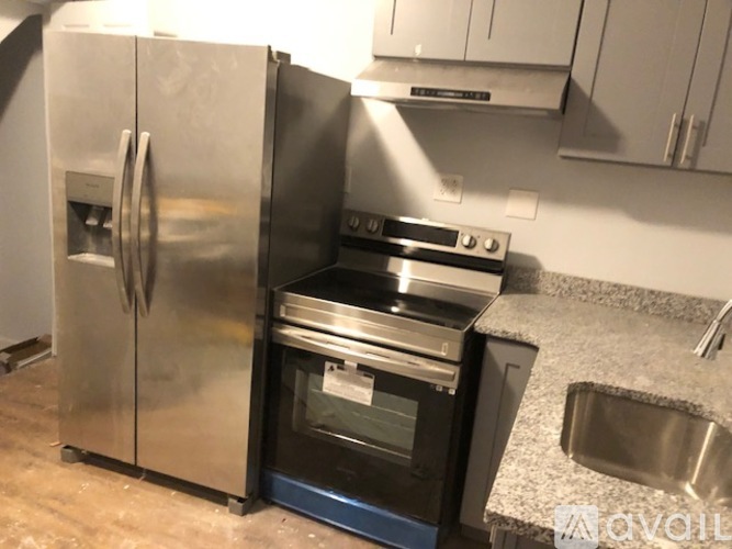 A kitchen with a stainless steel refrigerator, oven, and sink.