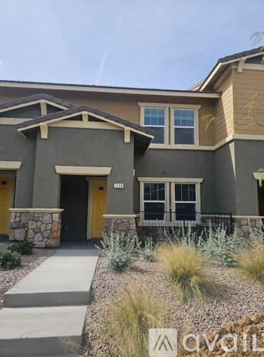 A modern house with a stone pillar and yellow doors.