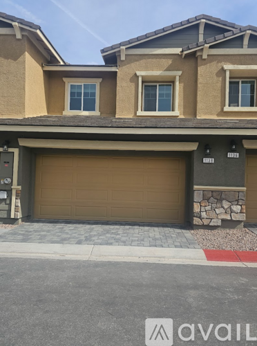 A house with a brown garage door and a stone pillar.