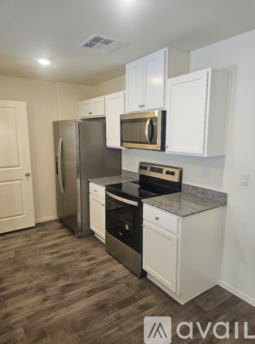 A kitchen with white cabinets and a black stove top oven.