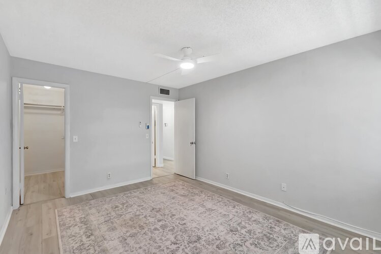 A room with a rug on the floor and a door on the left side.