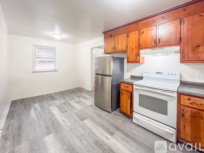 A kitchen with wooden cabinets and a white stove top oven.