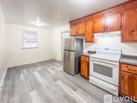 A kitchen with wooden cabinets and a white stove top oven.