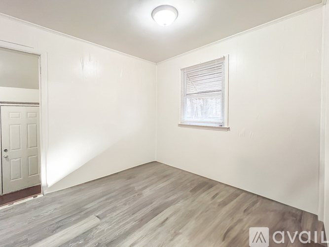 A room with a window and wooden flooring.