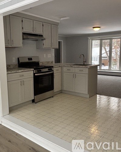 A kitchen with white cabinets and a black stove top oven.