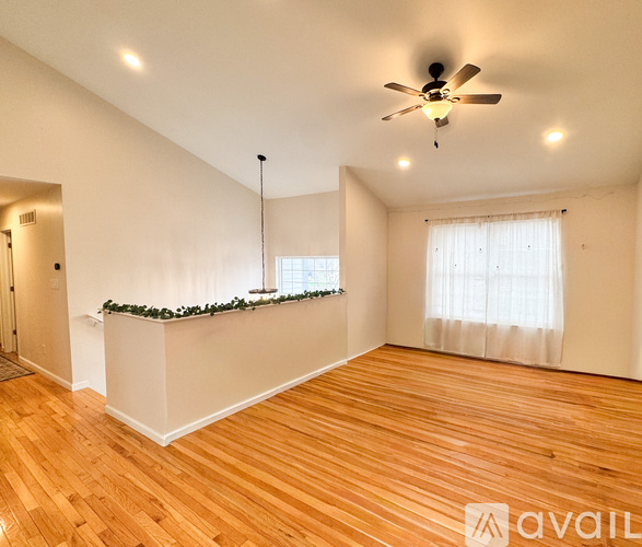 A room with wooden floors and a ceiling fan.