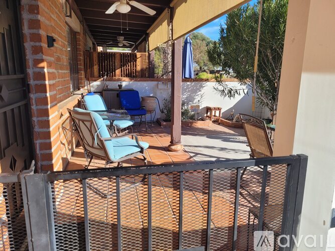 A patio with blue chairs and a table is shown.