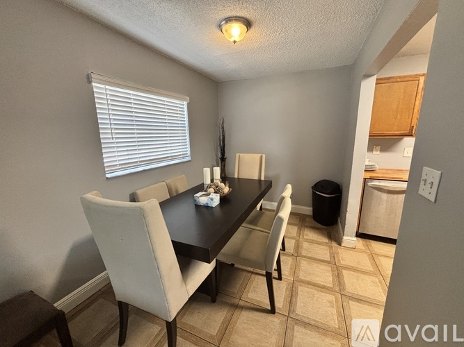 A dining room with a table and chairs.