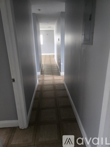 A long hallway with tiled floors and white walls.